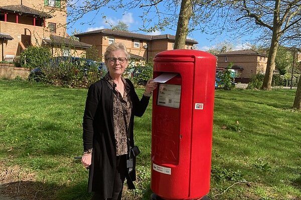 Marie Bradburn standing next to a postbox