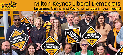 A group of Liberal Democrats holding Lib Dem diamond posters