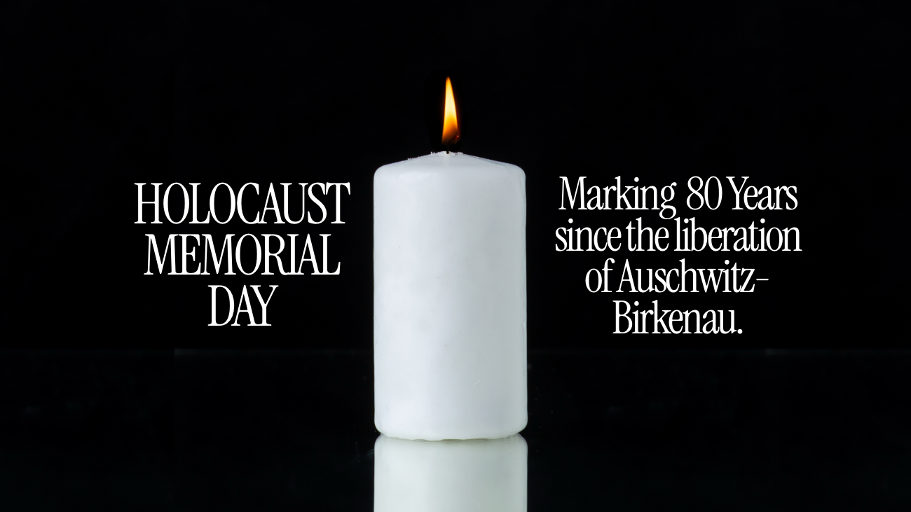 A burning white pillar candle with text either side reading Holocaust Memorial Day and Marking  80 Years  since the liberation of Auschwitz-Birkenau